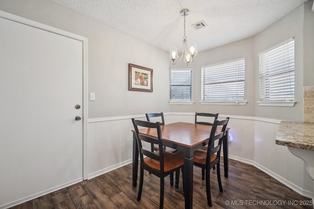 dining space with dark hardwood / wood-style flooring, a chandelier, and a textured ceiling