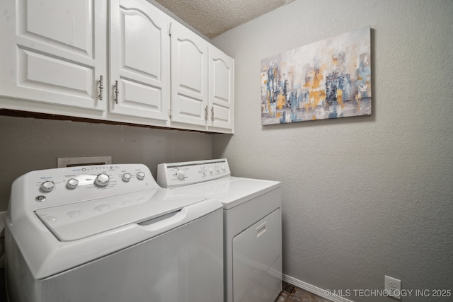 laundry room featuring cabinets, washer and dryer, and a textured ceiling