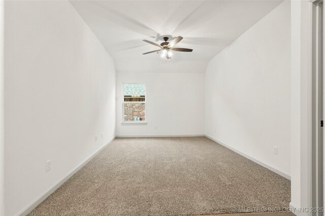 spare room with carpet floors, vaulted ceiling, and ceiling fan