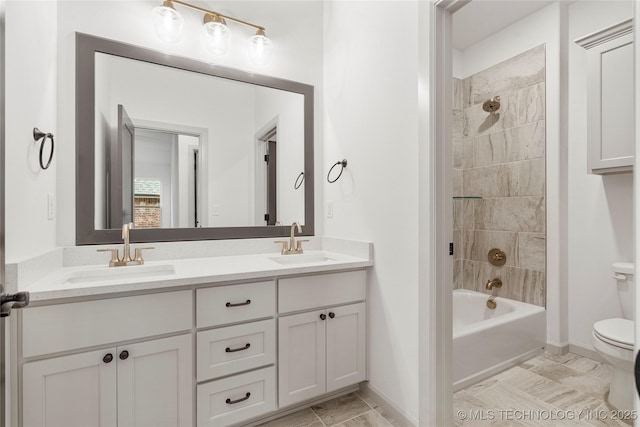 full bathroom with toilet, tiled shower / bath, and vanity