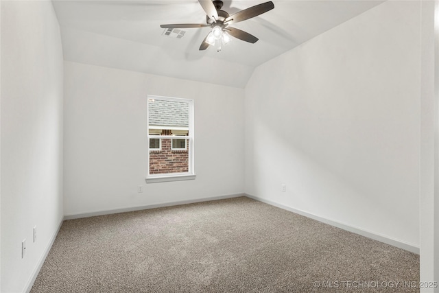 empty room featuring ceiling fan, vaulted ceiling, and carpet