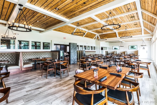 dining space featuring wood ceiling, beamed ceiling, light hardwood / wood-style floors, a notable chandelier, and high vaulted ceiling