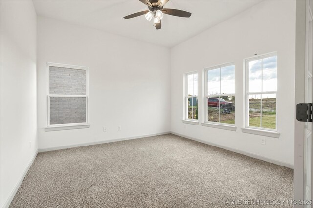 empty room featuring ceiling fan and carpet