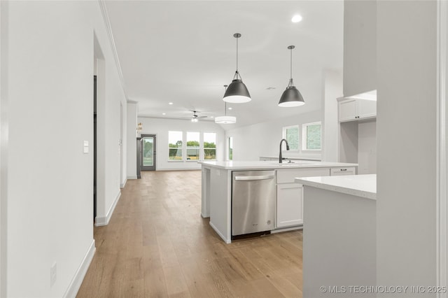 kitchen with stainless steel dishwasher, hanging light fixtures, sink, white cabinets, and a kitchen island with sink