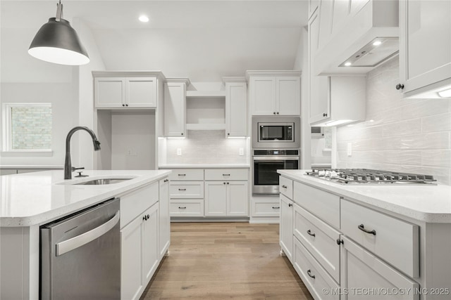 kitchen with pendant lighting, sink, stainless steel appliances, and white cabinets