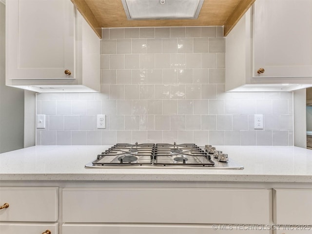 1412 N 70th St, Broken Arrow, OK 74014 - kitchen with stainless steel gas stovetop, backsplash, white cabinets, and light stone countertops
