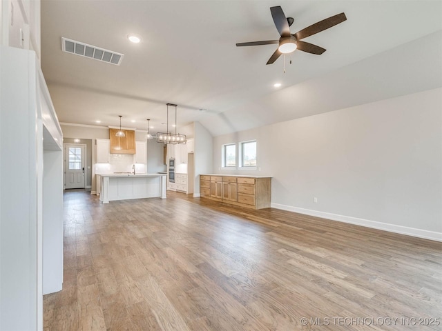 1412 N 70th St, Broken Arrow, OK 74014 - unfurnished living room with a ceiling fan, light wood finished floors, recessed lighting, and vaulted ceiling