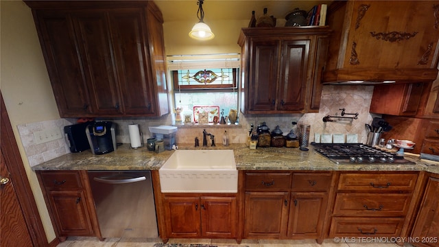 kitchen with sink, appliances with stainless steel finishes, hanging light fixtures, tasteful backsplash, and light stone countertops