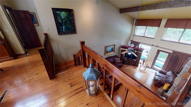 stairway featuring hardwood / wood-style flooring and beam ceiling