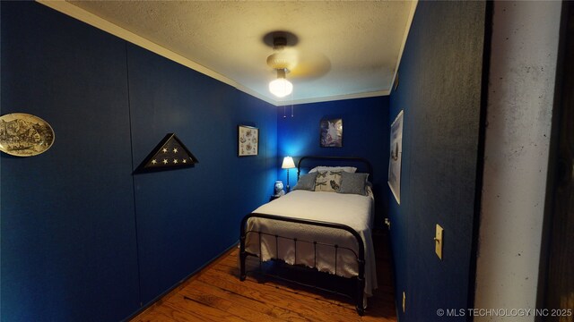 bedroom featuring a textured ceiling, dark wood-type flooring, and ceiling fan