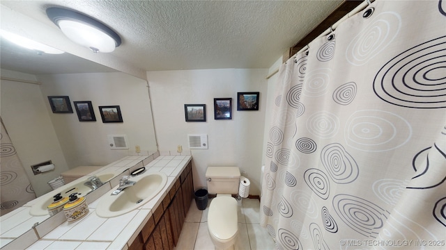 bathroom featuring vanity, tile patterned floors, a textured ceiling, and toilet