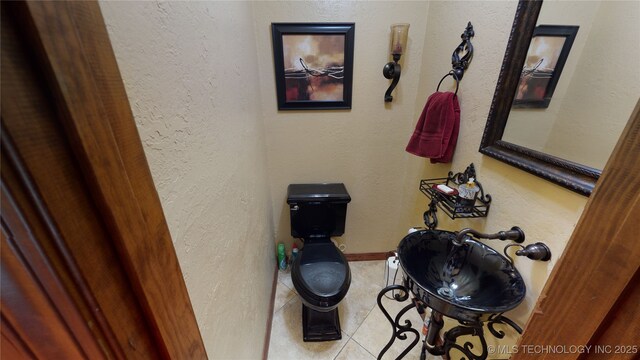 interior space featuring tile patterned floors and toilet