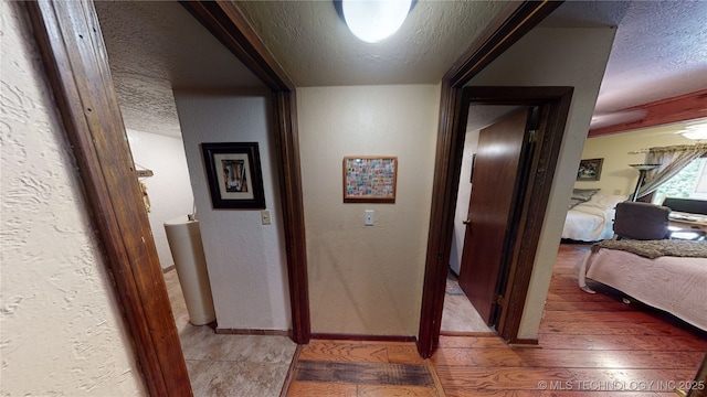 hallway with hardwood / wood-style floors and a textured ceiling