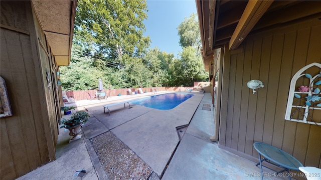 view of swimming pool with a patio and a diving board