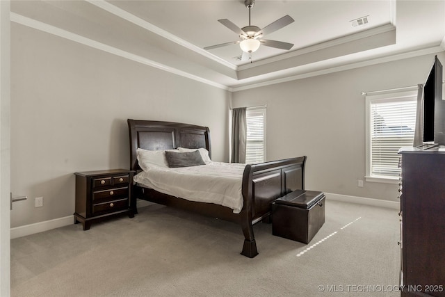 bedroom featuring ceiling fan, a tray ceiling, ornamental molding, and light carpet