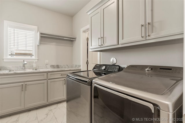 clothes washing area with sink, cabinets, and independent washer and dryer