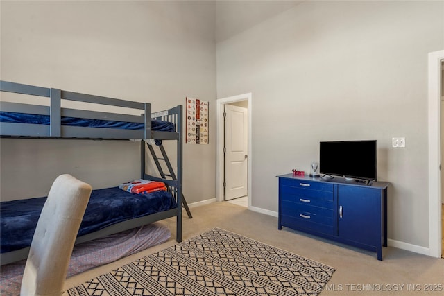 bedroom featuring light colored carpet and a towering ceiling