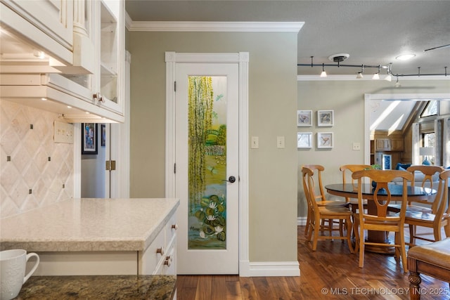 kitchen featuring crown molding, a textured ceiling, rail lighting, white cabinets, and dark wood-type flooring