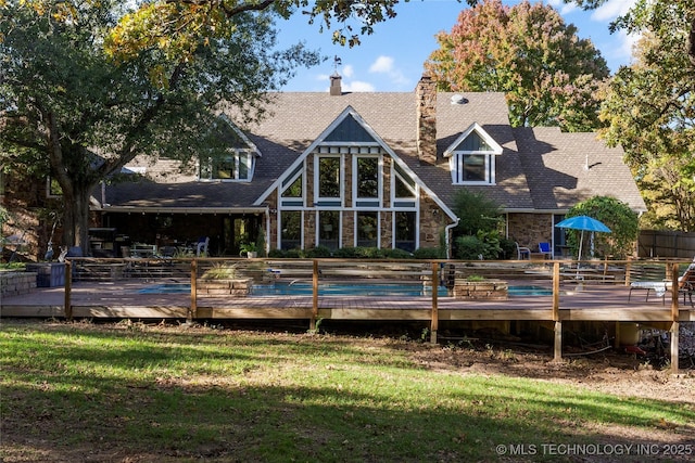 rear view of house with a deck and a yard