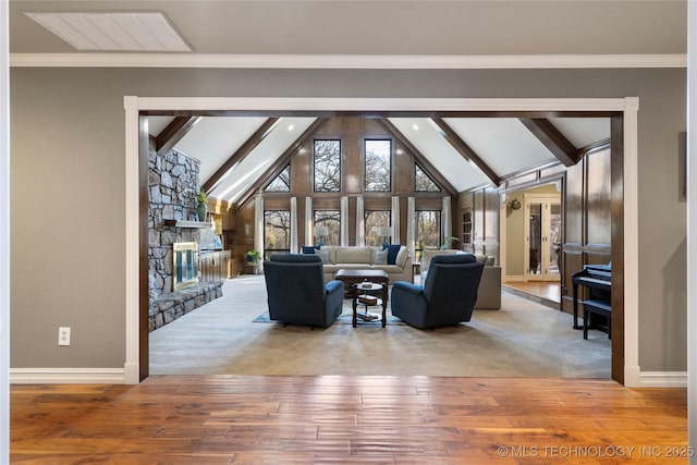 living room with beam ceiling, crown molding, a fireplace, and wood-type flooring