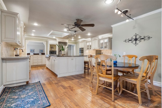 kitchen with white cabinets, kitchen peninsula, and tasteful backsplash