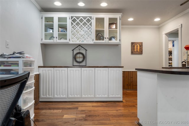 kitchen with dark hardwood / wood-style flooring, white cabinetry, and ornamental molding