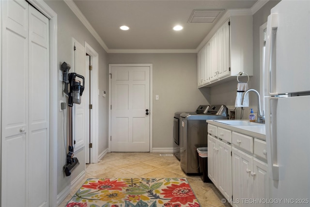 laundry area with sink, light tile patterned floors, washer and dryer, cabinets, and ornamental molding