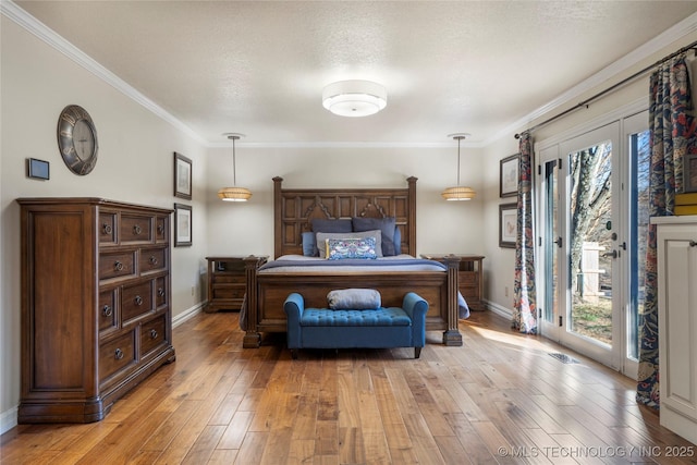 bedroom featuring access to exterior, ornamental molding, light hardwood / wood-style floors, and multiple windows