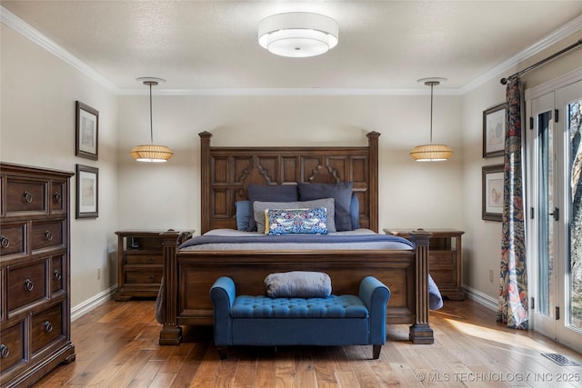 bedroom with hardwood / wood-style floors and ornamental molding