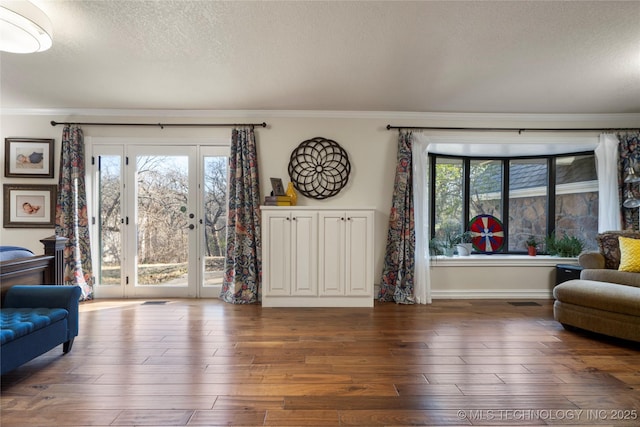 living room featuring a textured ceiling, dark hardwood / wood-style floors, and crown molding