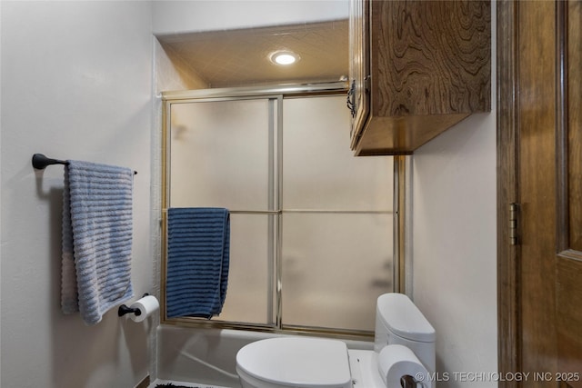 bathroom featuring shower / bath combination with glass door and toilet