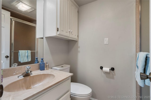 bathroom featuring a shower with door, toilet, and vanity