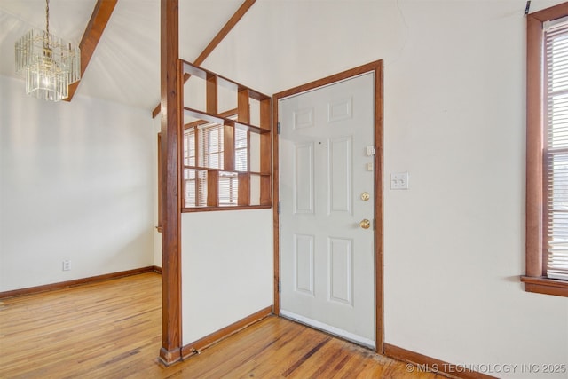 foyer entrance with plenty of natural light, light hardwood / wood-style flooring, and a notable chandelier