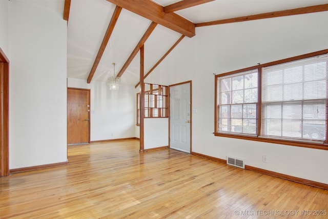 unfurnished room with light wood-type flooring, high vaulted ceiling, and beam ceiling