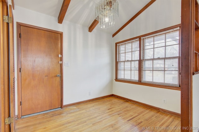 empty room featuring light wood-type flooring, lofted ceiling with beams, and a notable chandelier