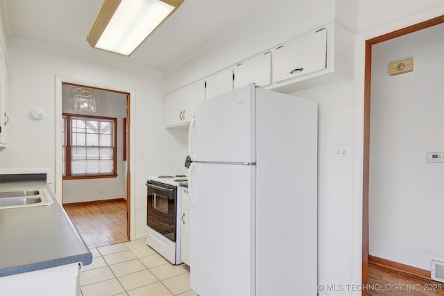 kitchen featuring sink, white appliances, white cabinets, and light tile patterned flooring