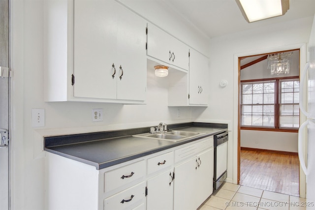 kitchen featuring light tile patterned floors, sink, dishwashing machine, and white cabinets