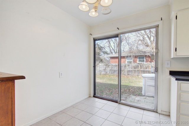 unfurnished dining area featuring a notable chandelier and light tile patterned flooring