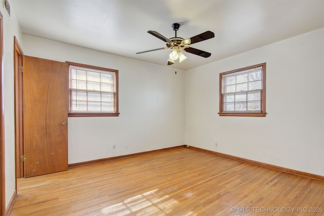 spare room with ceiling fan, plenty of natural light, and light wood-type flooring