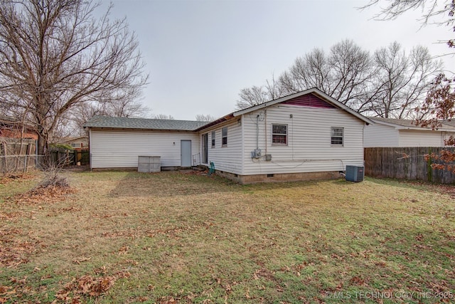 back of property featuring cooling unit and a yard