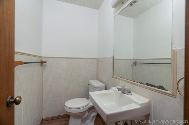 bathroom with sink, toilet, and a textured ceiling