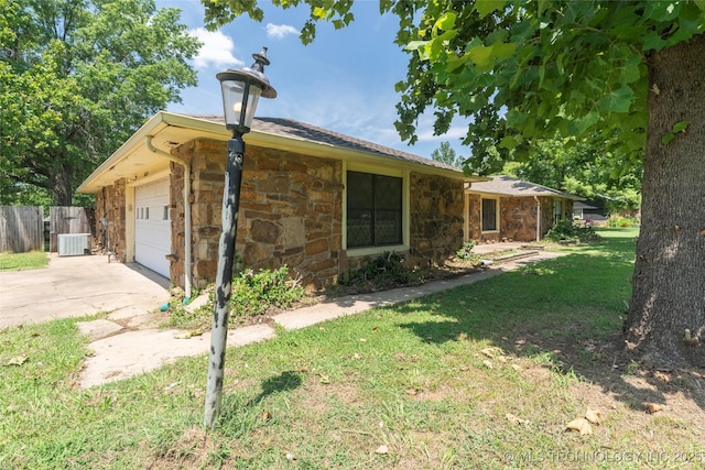 view of front of home featuring a garage, a front yard, and cooling unit