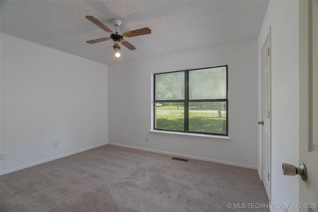 carpeted empty room featuring ceiling fan and a textured ceiling