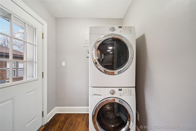 laundry area featuring stacked washer / drying machine and dark hardwood / wood-style flooring