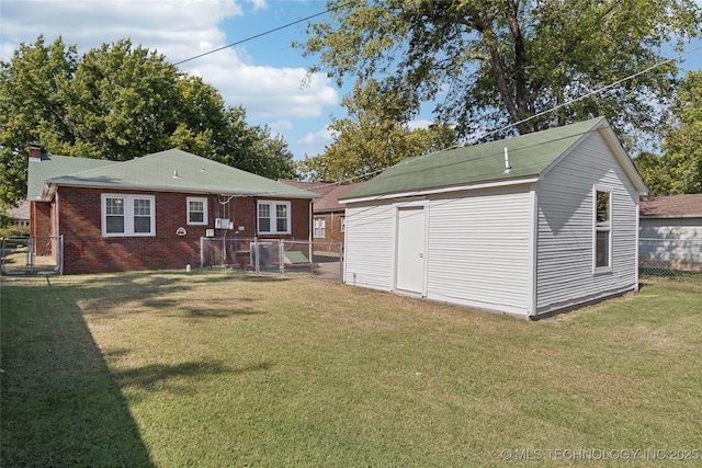 rear view of house featuring an outdoor structure and a yard