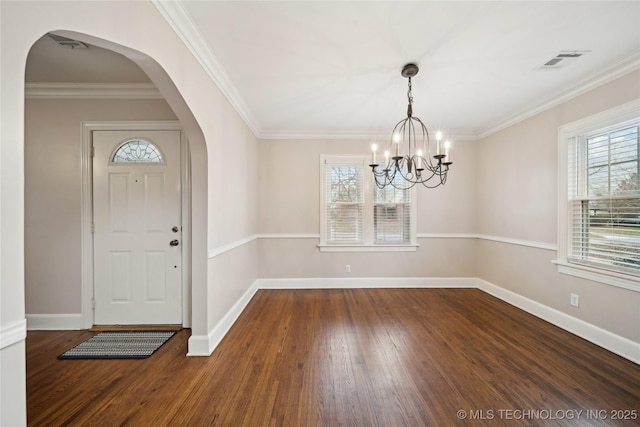 entrance foyer with wood-type flooring, ornamental molding, and a chandelier