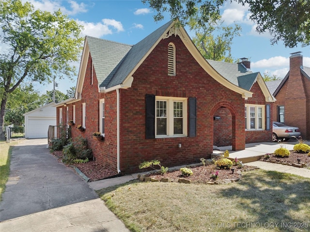 view of front facade featuring a front yard, an outbuilding, and a garage