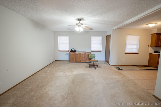 unfurnished living room with light tile patterned floors, a textured ceiling, and ceiling fan