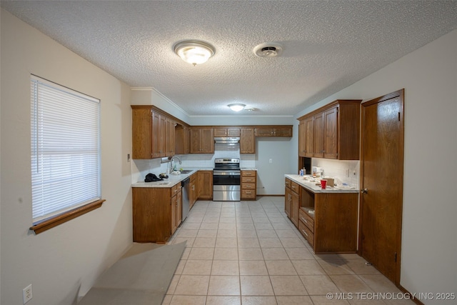 kitchen with sink, light tile patterned floors, a textured ceiling, and appliances with stainless steel finishes