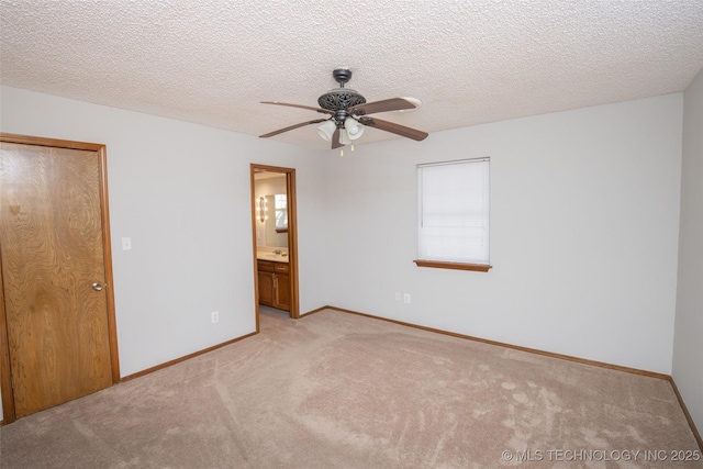 unfurnished bedroom featuring ceiling fan, ensuite bath, a closet, and a textured ceiling